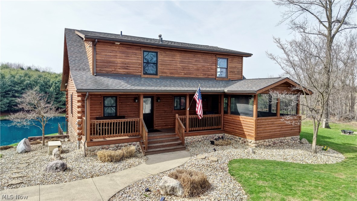View of front of property featuring a shingled roof and a porch