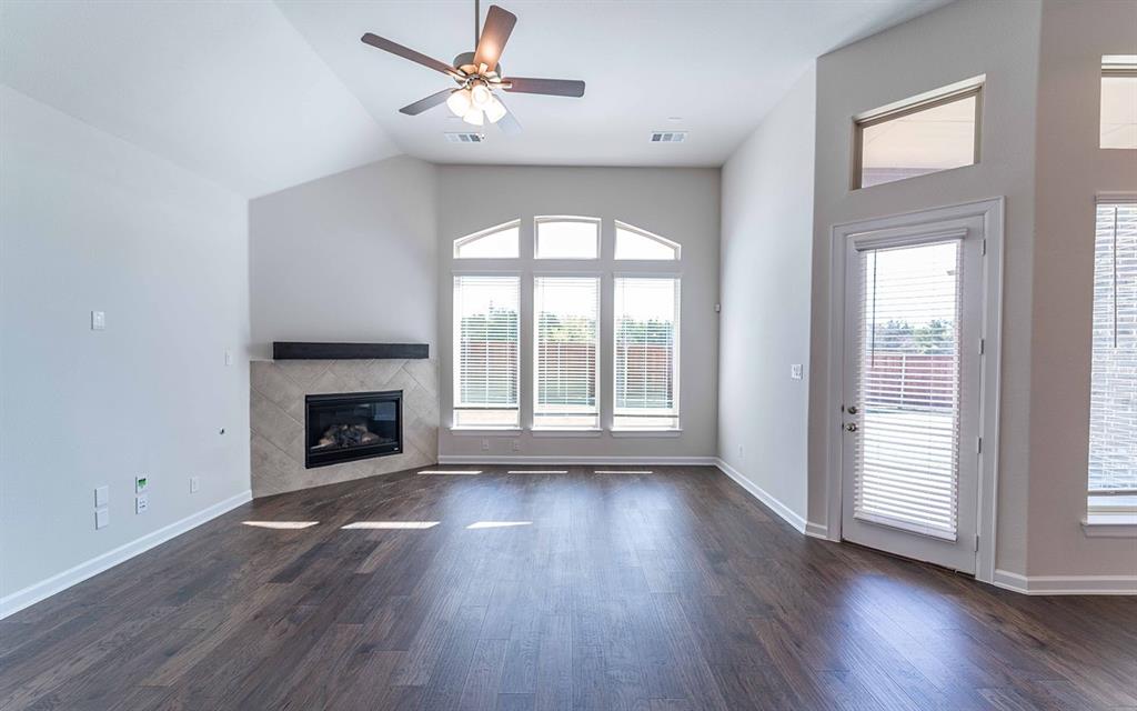 1907 Rondinella Drive Rockwall, TX 75032 - Photo 2 of 21 an empty room with wooden floor fireplace and windows