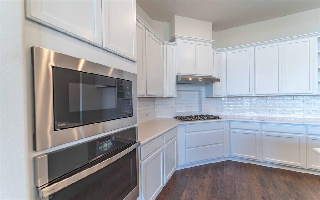 1907 Rondinella Drive Rockwall, TX 75032 - Photo 6 of 21 a kitchen with stainless steel appliances granite countertop a stove and a microwave