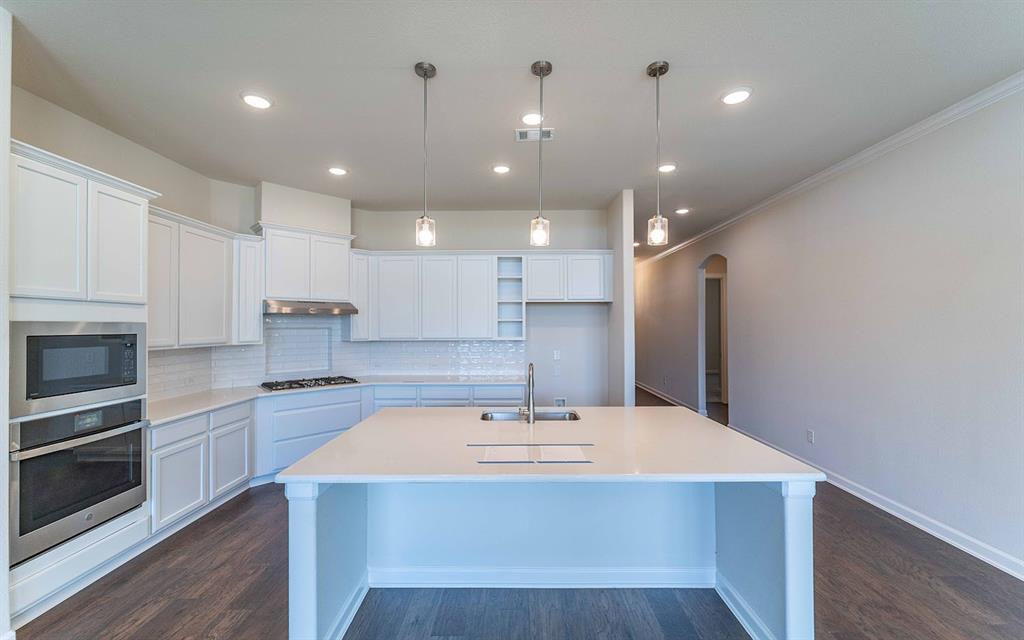 1907 Rondinella Drive Rockwall, TX 75032 - Photo 7 of 21 a kitchen with kitchen island a sink stainless steel appliances and cabinets