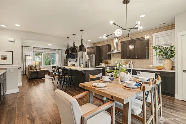 a view of a dining room and livingroom with furniture wooden floor a chandelier