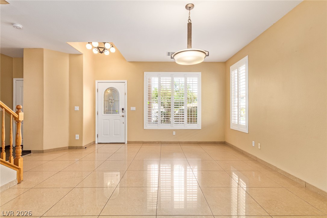 1477 Rancho Ridge Drive Henderson, NV 89012 - Photo 6 of 46 A welcoming entryway with lustrous tiled flooring and inviting natural light through shuttered windows.