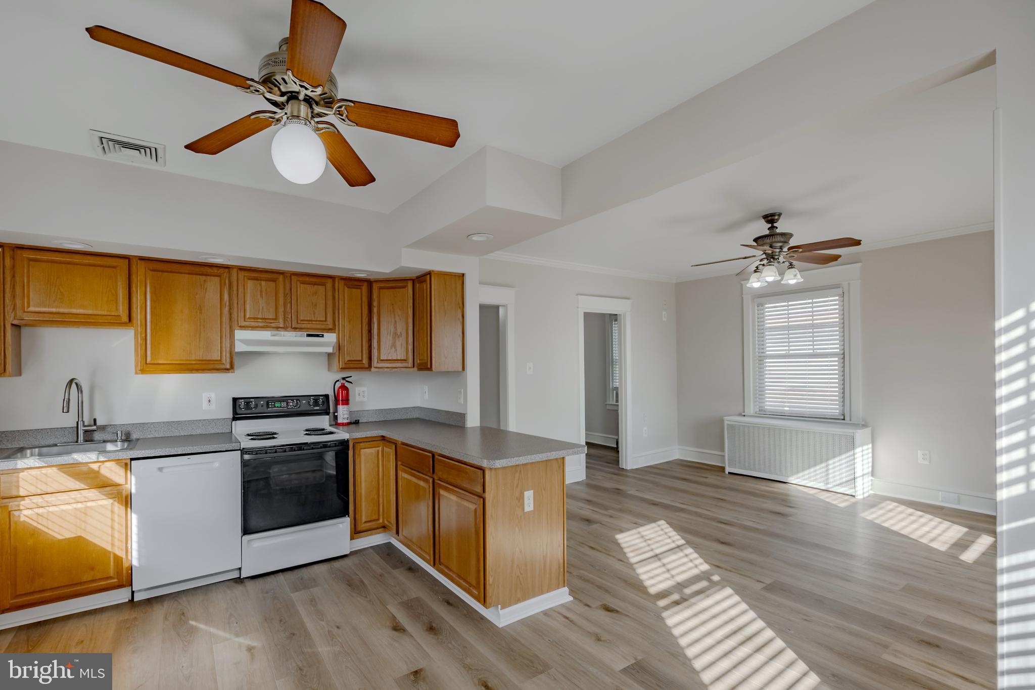 a kitchen with stainless steel appliances granite countertop a sink cabinets and wooden floor