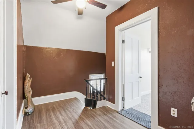 a view of a hallway with wooden floor and staircase