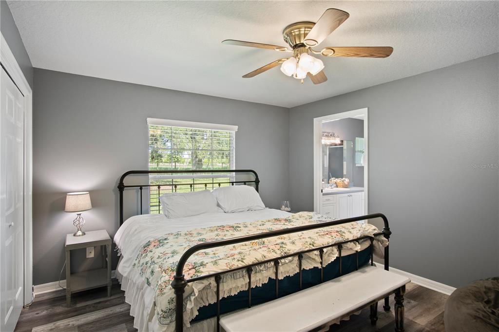 9045 Lake Hatchineha Road Kissimmee, FL 34759 - Photo 35 of 47 a bedroom with a bed and a chandelier
