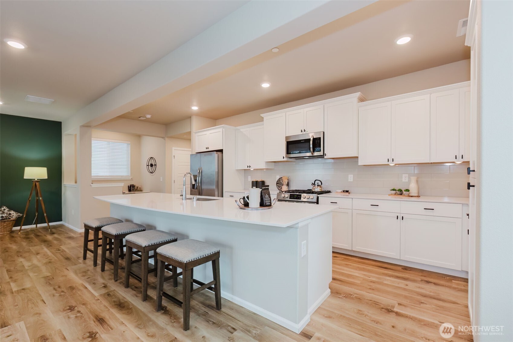916 Baker Heights Loop Bremerton, WA 98312 - Photo 9 of 40 a kitchen with a sink a stove a refrigerator and white cabinets with wooden floor