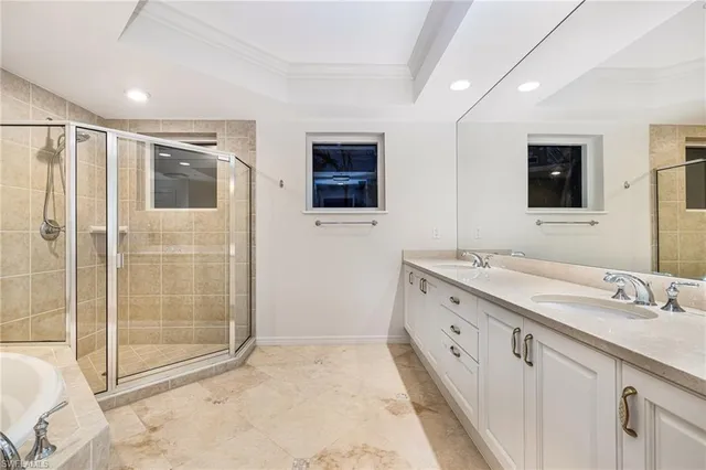 a spacious bathroom with a double vanity sink a large mirror and shower