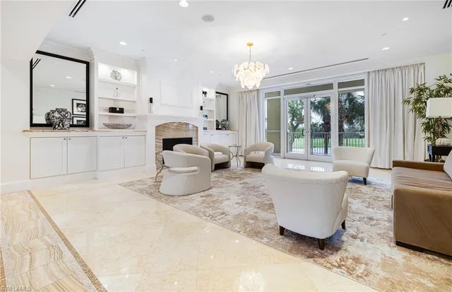 a living room with fireplace furniture and a large window