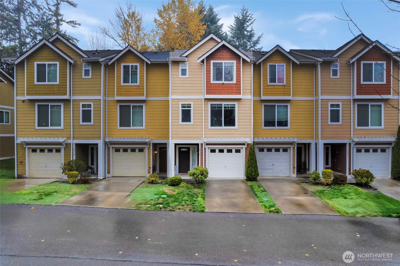 a front view of a house with a yard and trees