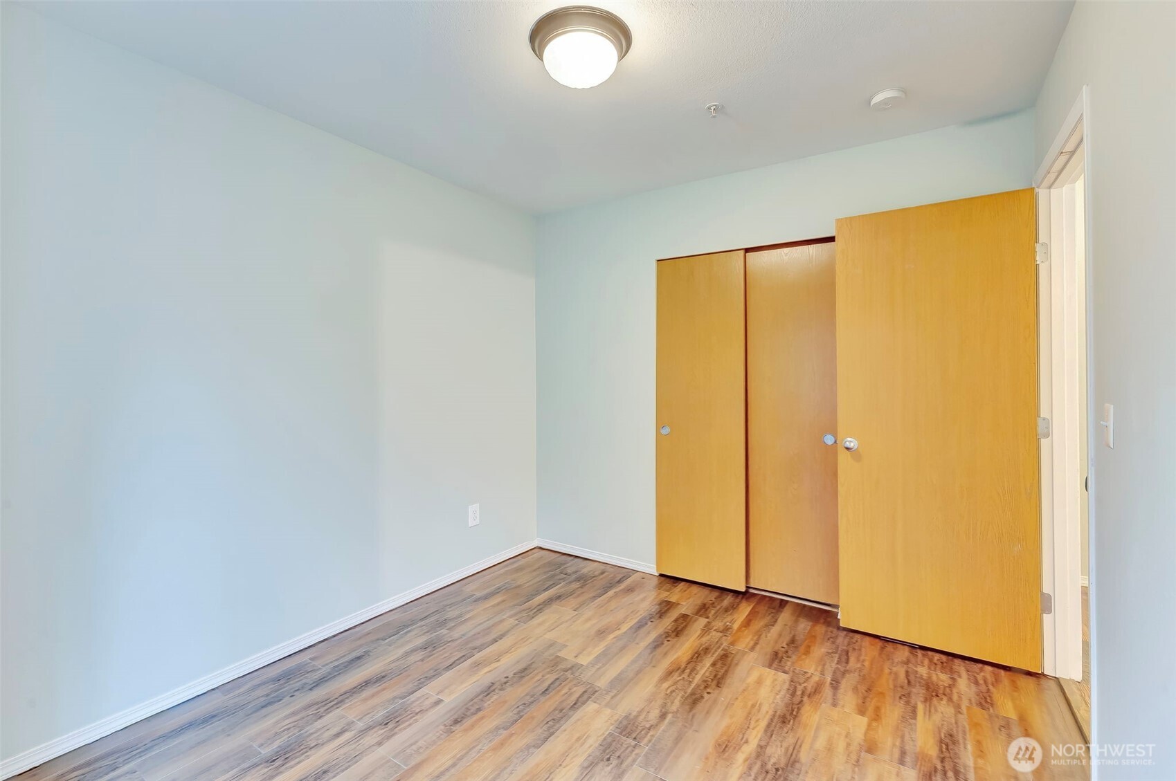 5319 147th St Court East, Unit 5 Tacoma, WA 98446 - Photo 18 of 30 a view of an empty room with wooden floor and a window