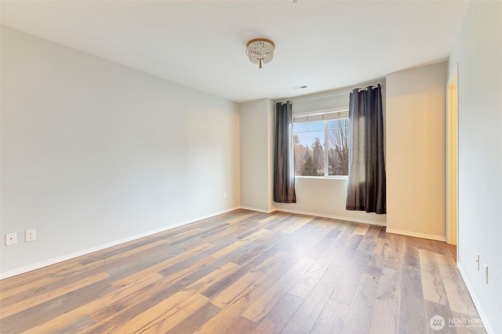 5319 147th St Court East, Unit 5 Tacoma, WA 98446 - Photo 22 of 30 a view of an empty room with wooden floor and a window