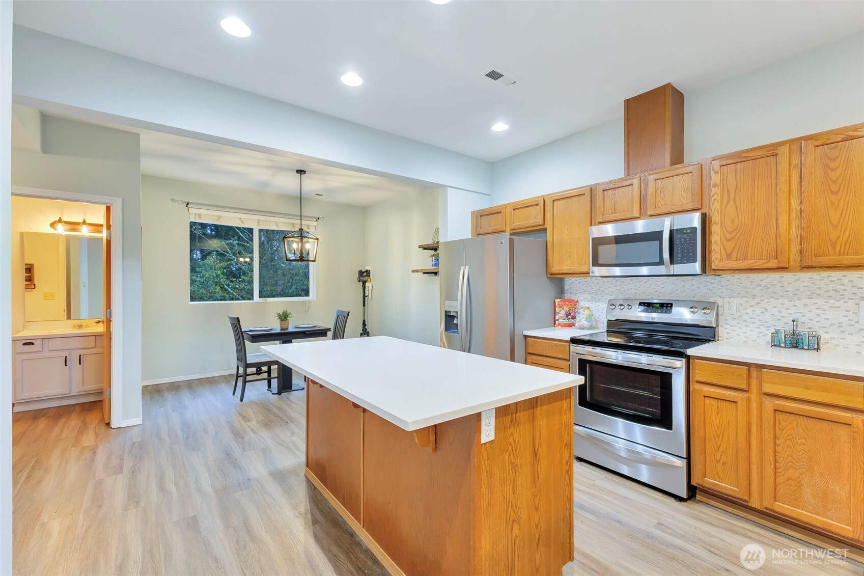 5319 147th St Court East, Unit 5 Tacoma, WA 98446 - Photo 6 of 30 a kitchen with stainless steel appliances a stove top oven a sink dishwasher and a refrigerator with wooden floor