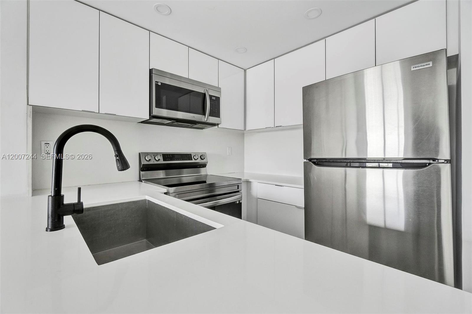 620 Southwest 10th Street, Unit 301 Miami, FL 33130 - Photo 2 of 20 a kitchen with a refrigerator and a sink