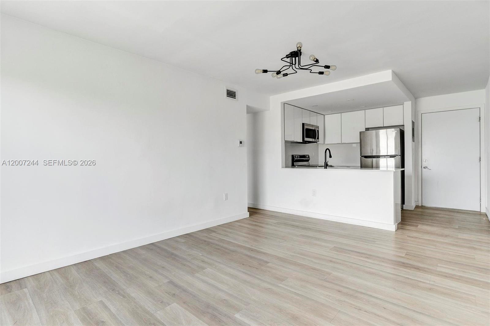 620 Southwest 10th Street, Unit 301 Miami, FL 33130 - Photo 6 of 20 a view of a kitchen with a sink refrigerator and wooden floor