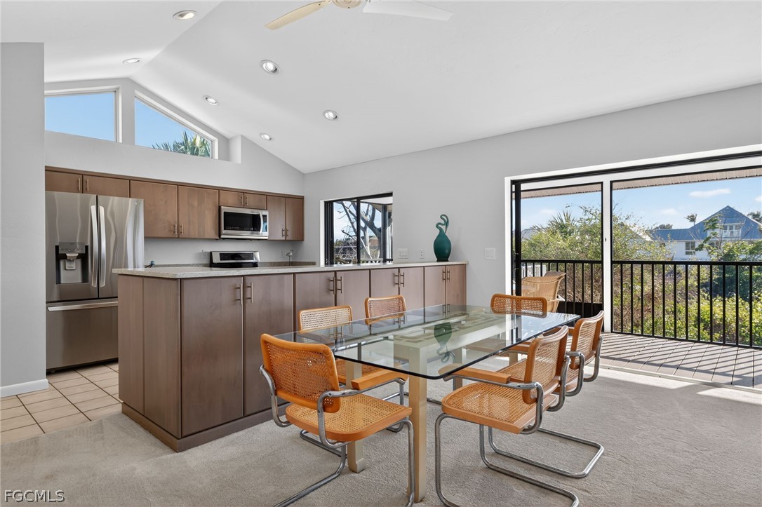 4562 Bowen Bayou Road Sanibel, FL 33957 - Photo 11 of 38 a kitchen with stainless steel appliances granite countertop a stove top oven a sink dishwasher a dining table and chairs with wooden floor
