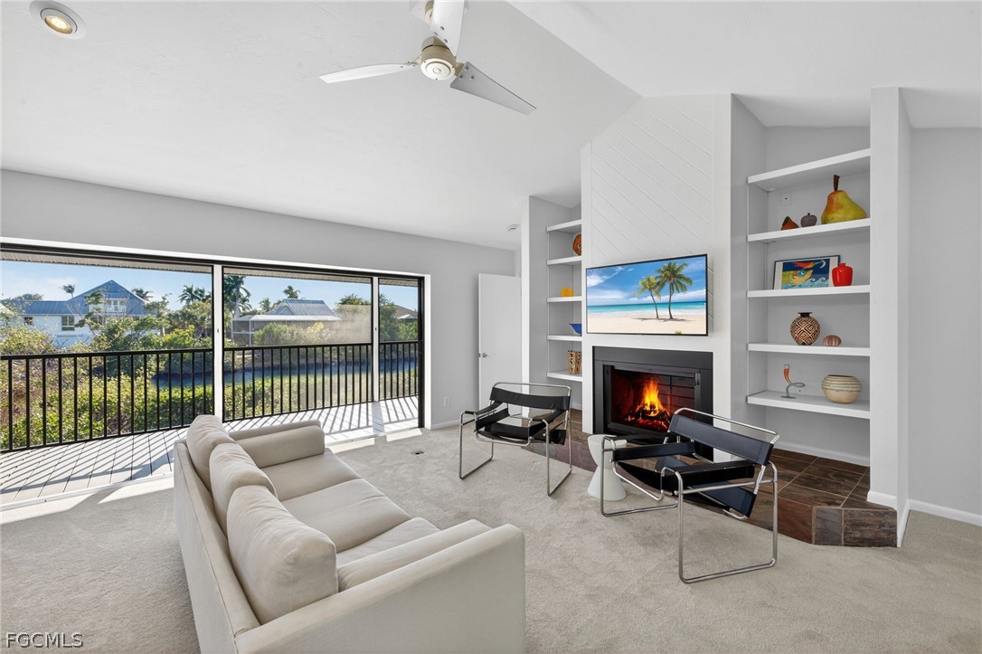 4562 Bowen Bayou Road Sanibel, FL 33957 - Photo 10 of 38 a living room with furniture a fireplace and a floor to ceiling window