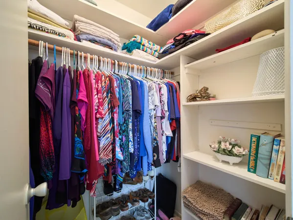 a view of walk in closet with clothes and shoes