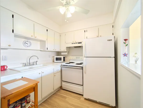 a kitchen with stainless steel appliances granite countertop a refrigerator sink and white cabinets