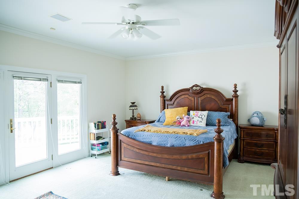 687 Ed Lester Road Roxboro, NC 27574 - Photo 39 of 63 a bedroom with a bed and a chandelier