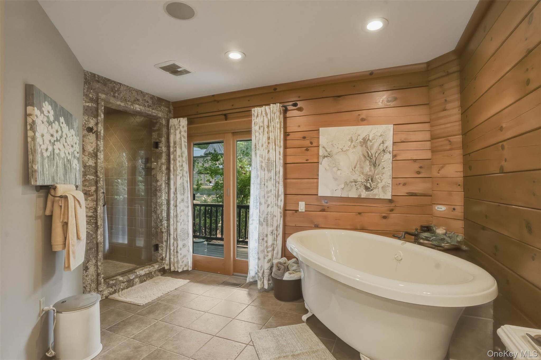 95 Judson Road Montgomery, NY 12549 - Photo 19 of 50 luxurious primary suite complete with a walk-in closet and spa-inspired ensuite featuring a floating jetted soaking tub, oversized tiled shower, and double vanity. Nearly every room opens directly to inviting outdoor living spaces that seamlessly connect the home to its natural surroundings.