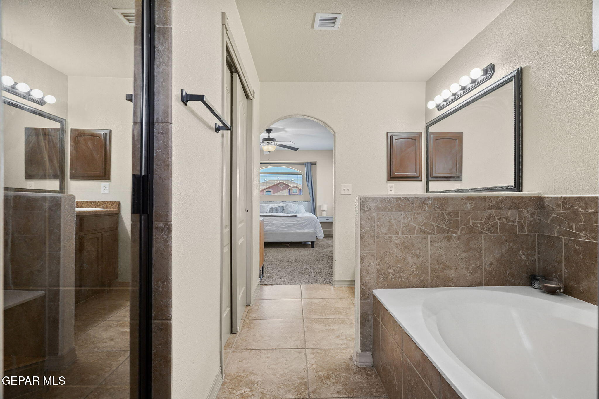3152 Rustic Hidden Drive El Paso, TX 79938 - Photo 20 of 38 a bathroom with a tub a mirror and a shower