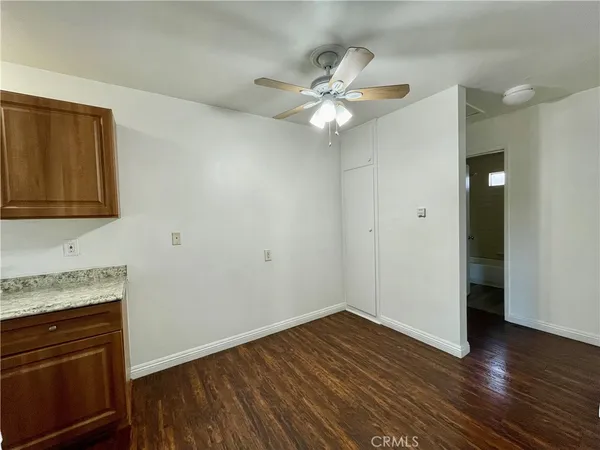 a view of a kitchen with wooden floor and electronic appliances