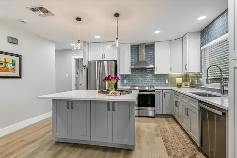 a kitchen with stainless steel appliances granite countertop a sink stove and refrigerator
