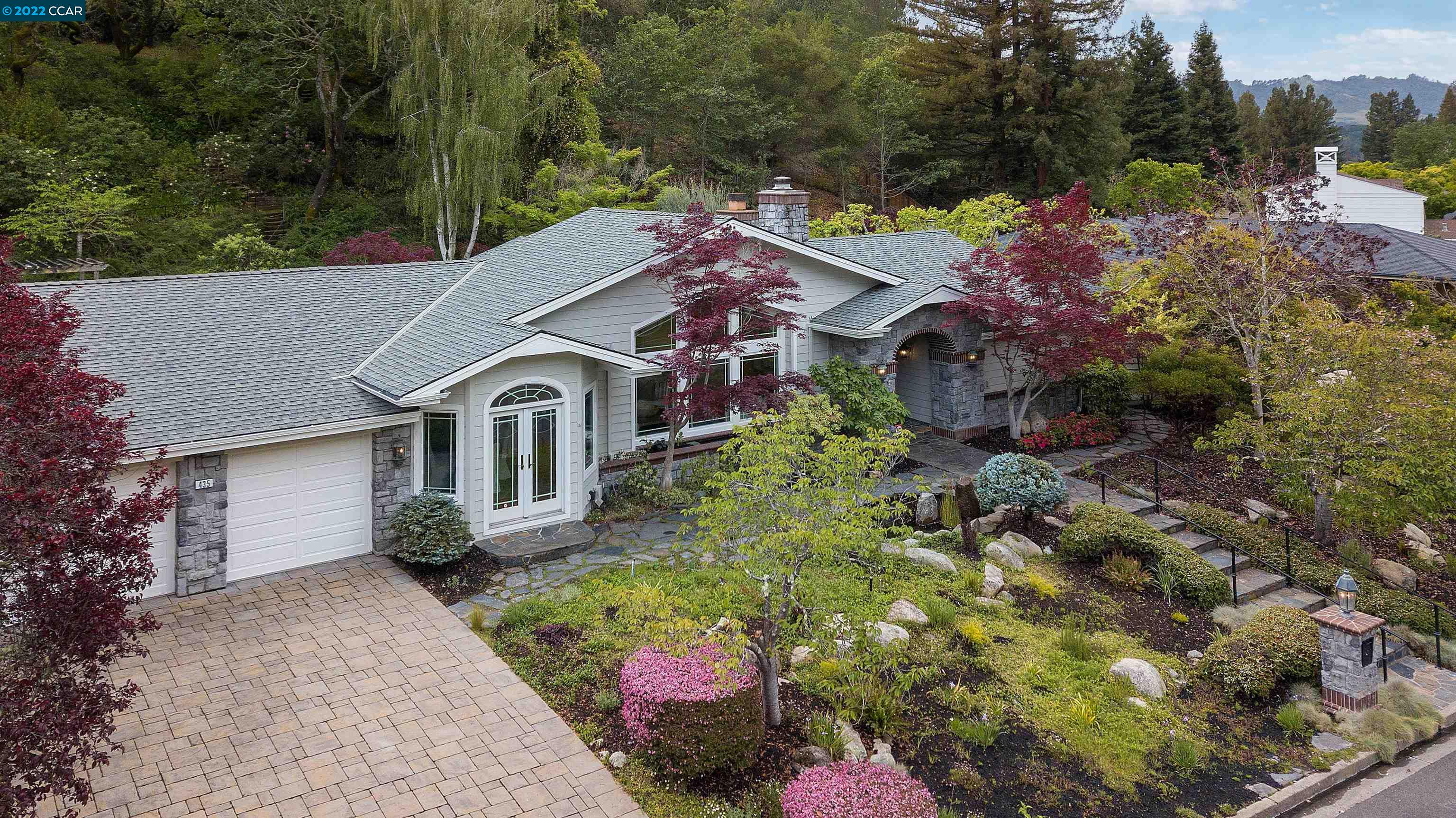 a aerial view of a house with a yard and potted plants