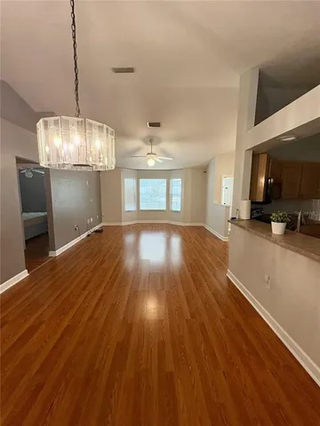 a view of a room with wooden floor fireplace and window