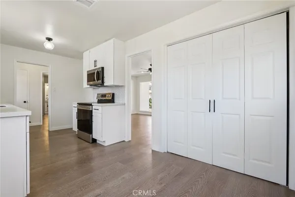 a kitchen with white cabinets and white appliances