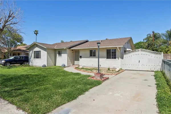 a front view of a house with a garden and yard
