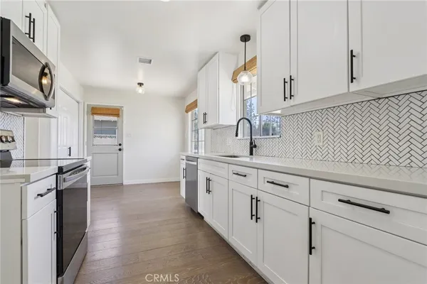 a kitchen with granite countertop white cabinets and white appliances