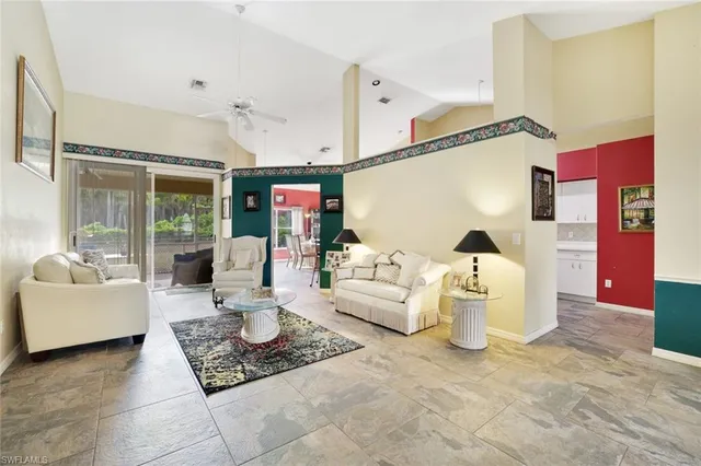 a living room with furniture and a view of kitchen