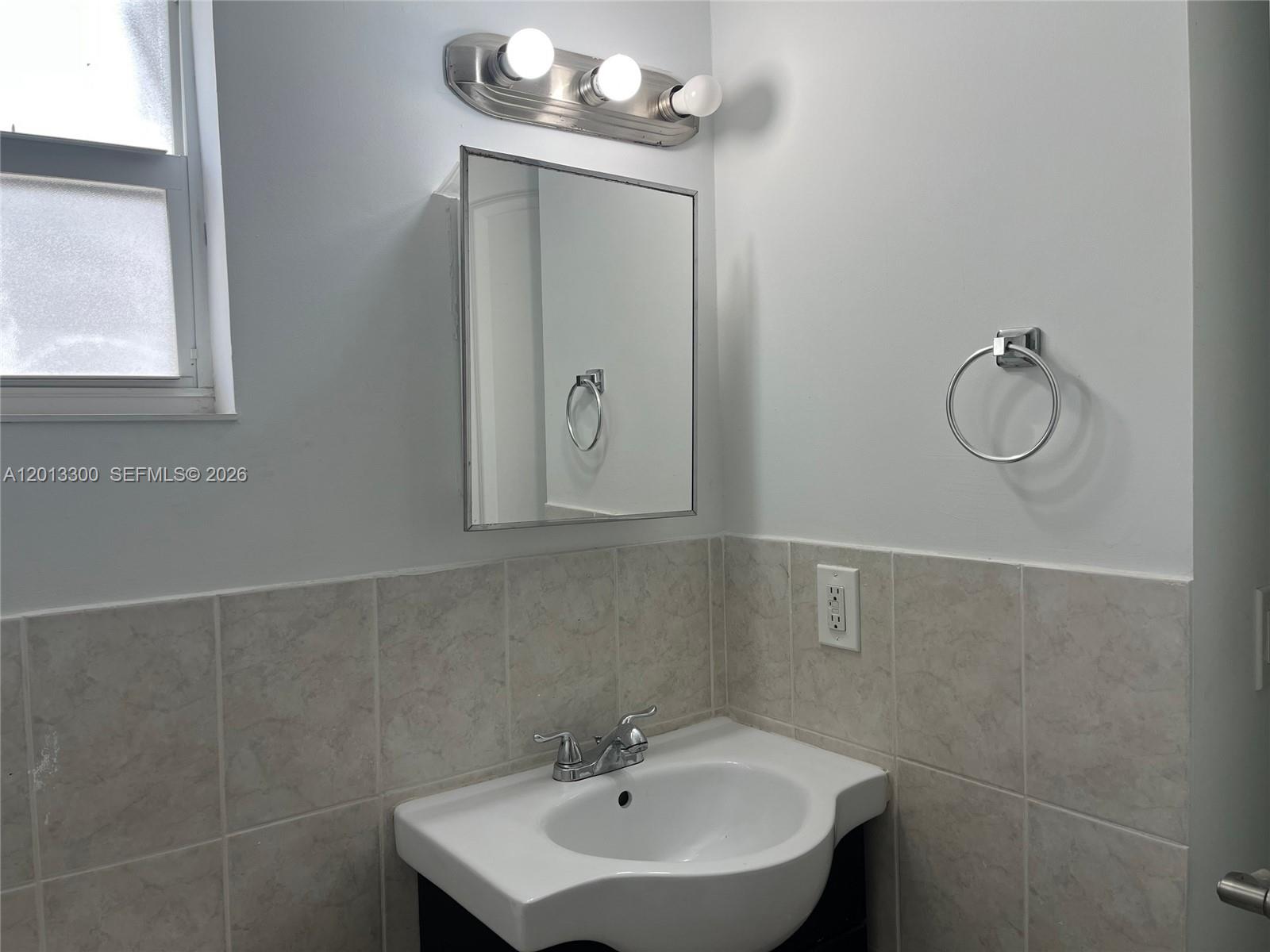 1020 Southwest 4th Street, Unit 102 Miami, FL 33130 - Photo 11 of 14 a bathroom with a sink a mirror and a window