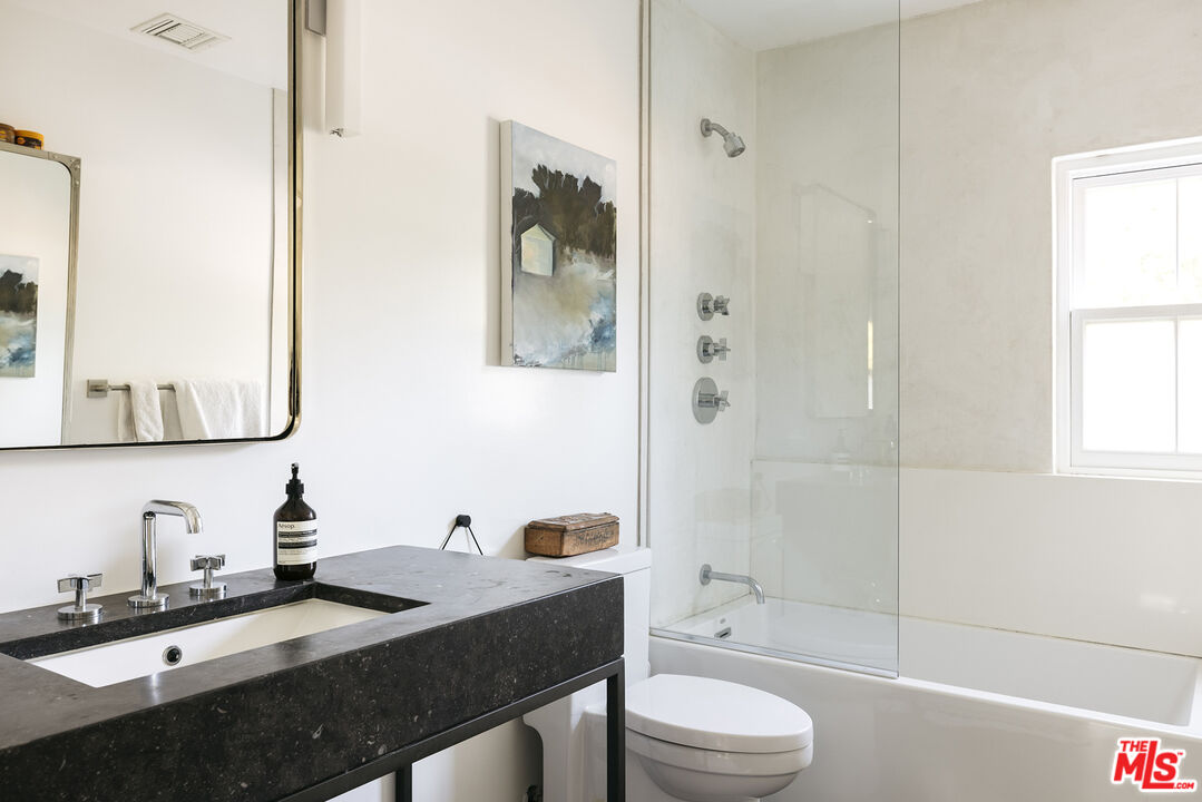 461 West Rustic Road Santa Monica, CA 90402 - Photo 20 of 31 a bathroom with a granite countertop sink toilet a mirror and shower