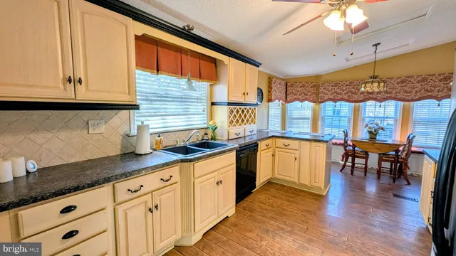 a kitchen with stainless steel appliances granite countertop a refrigerator a stove and a wooden floor