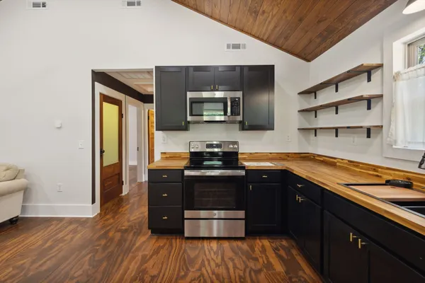 a living room with furniture a flat screen tv and kitchen view