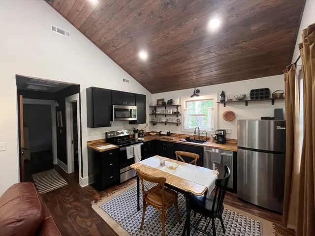 a living room with furniture a flat screen tv and kitchen view