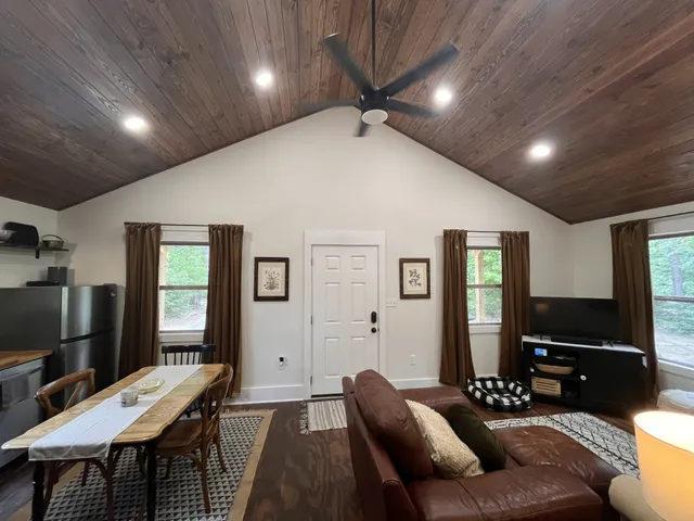 a living room with stainless steel appliances furniture and a flat screen tv