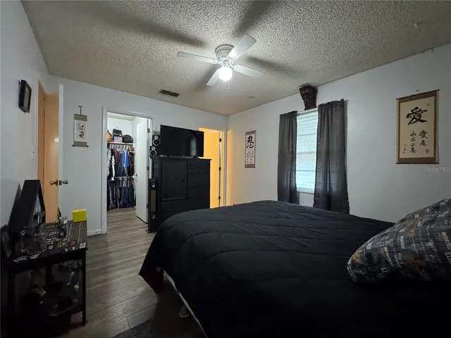 a bedroom with a bed and a flat tv screen