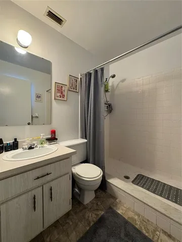 a bathroom with a sink a toilet a shower and a mirror