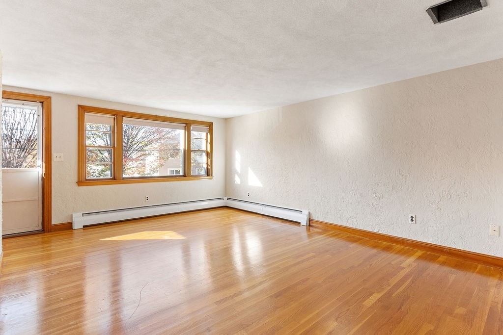 32 Duncan Road Everett, MA 02149 - Photo 4 of 30 an empty room with wooden floor and windows
