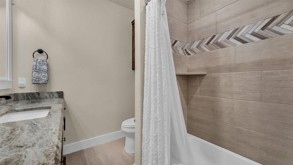 1320 Post Oak Road Gordon, TX 76453 - Photo 27 of 40 Bathroom featuring vanity, shower / tub combo with curtain, and light wood-style flooring