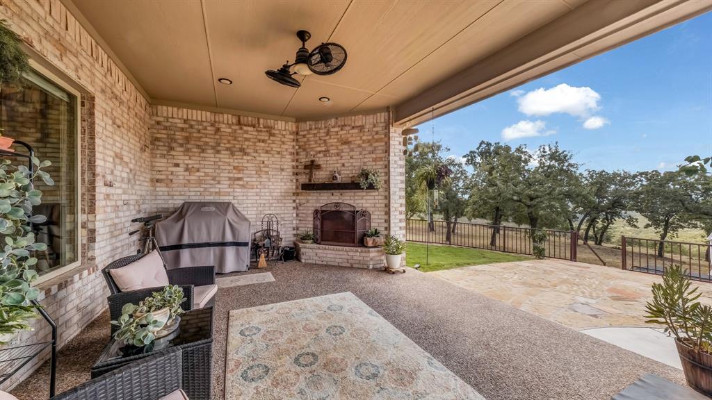 1320 Post Oak Road Gordon, TX 76453 - Photo 36 of 40 Fenced backyard featuring an outdoor brick fireplace, a patio area, and a grill