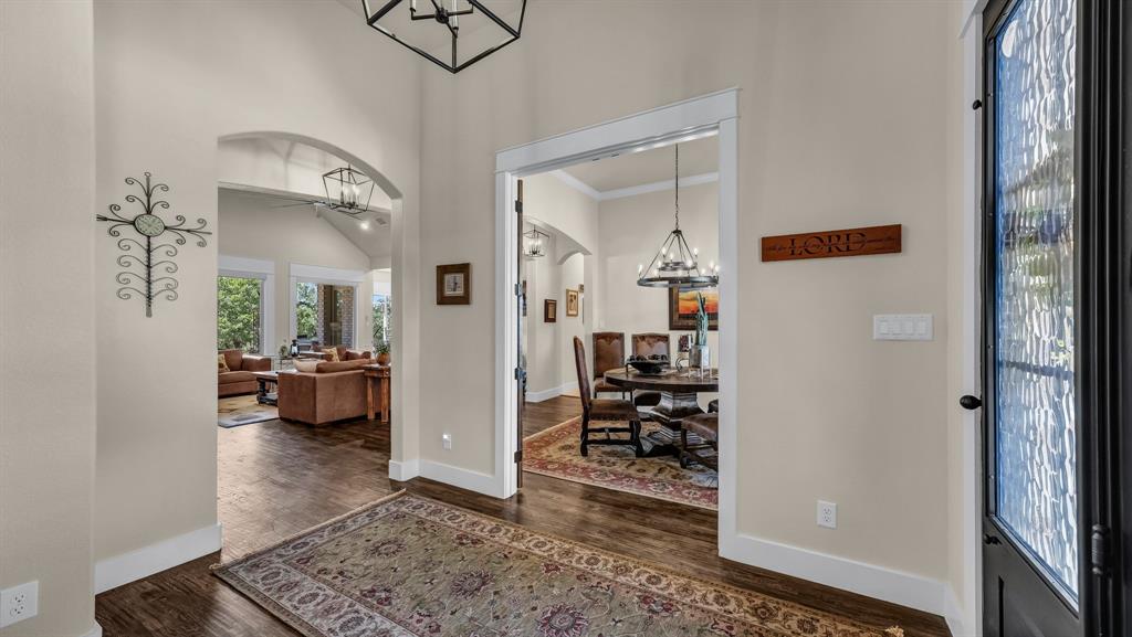 1320 Post Oak Road Gordon, TX 76453 - Photo 4 of 40 Entrance foyer with arched walkways, a high ceiling, a chandelier, dark wood-type flooring, and crown molding