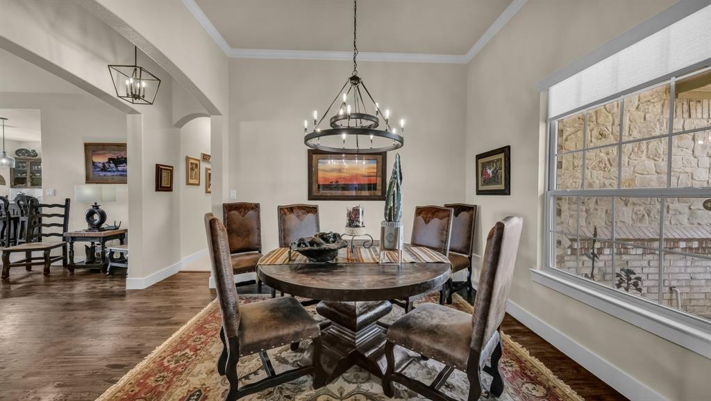 1320 Post Oak Road Gordon, TX 76453 - Photo 7 of 40 Dining space featuring a chandelier, dark wood finished floors, ornamental molding, and arched walkways