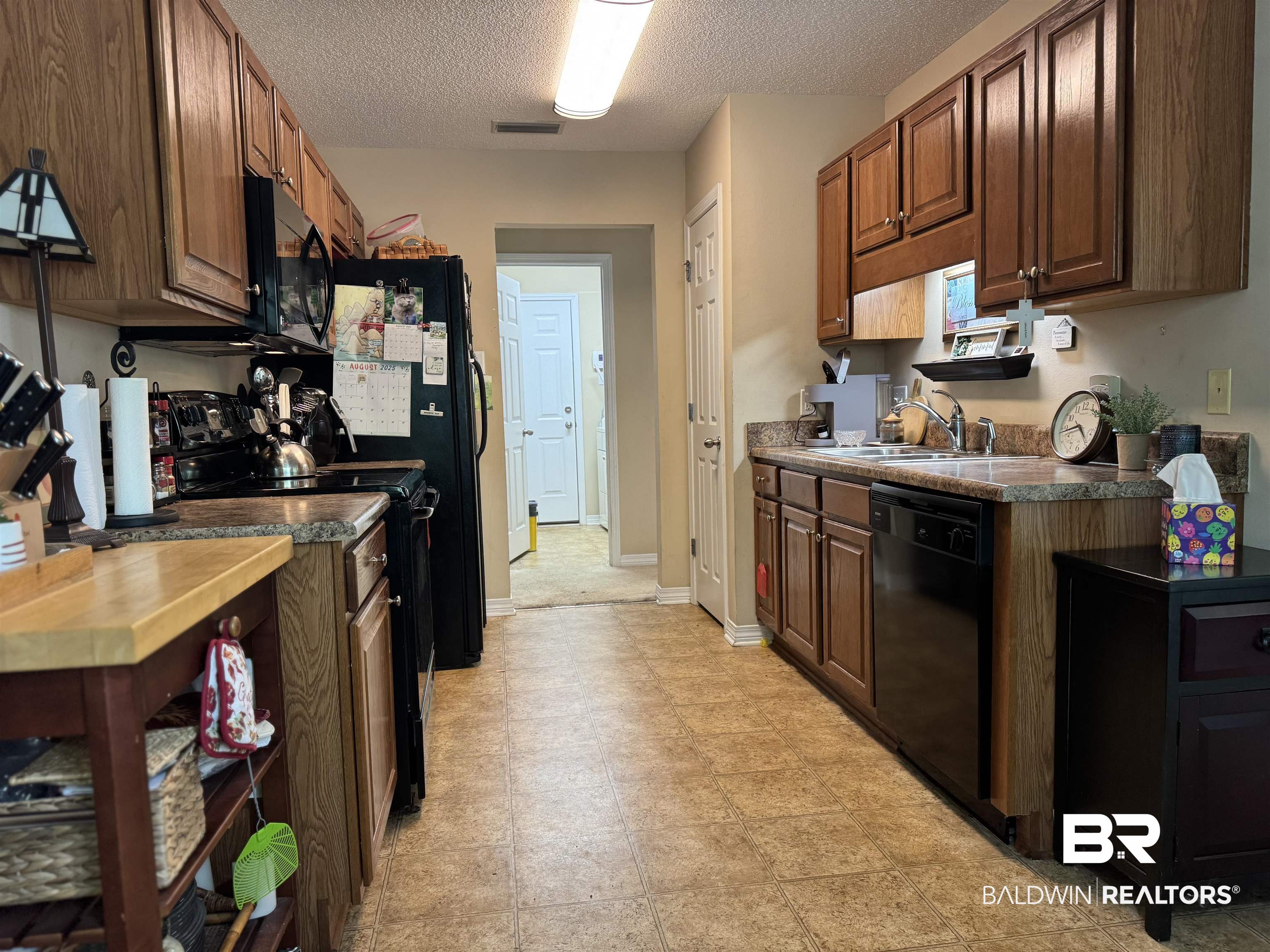 2245 Spring Grove North Mobile, AL 36695 - Photo 5 of 10 Kitchen featuring black appliances, a textured ceiling, and dark countertops
