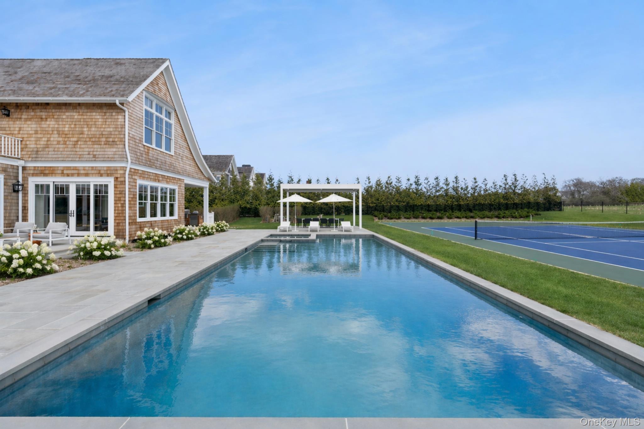 450 7 Ponds Towd Road Water Mill, NY 11976 - Photo 29 of 32 a view of swimming pool with seating area and trees in the background