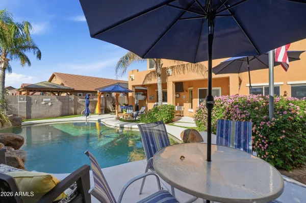 a view of a patio with table and chairs under an umbrella