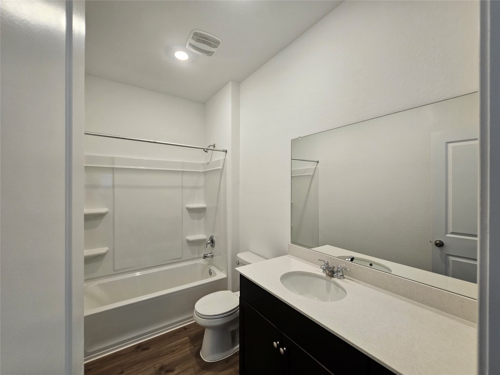 856 Rancho Del Cielo Loop Jarrell, TX 76537 - Photo 17 of 35 a bathroom with a granite countertop sink toilet mirror and bathtub